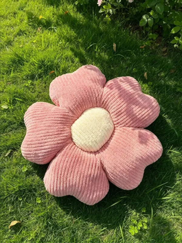 Roze Cuddle Puff jastuk u obliku cvetića od rebrastog pliša, sa krem sredinom, na travi