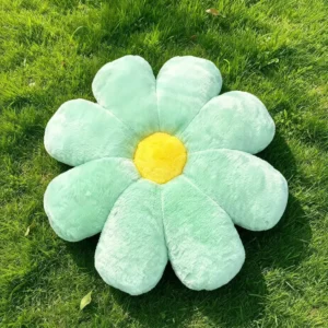 Mint zeleni Cuddle Puff jastuk u obliku cvetića sa žutom sredinom, na travi