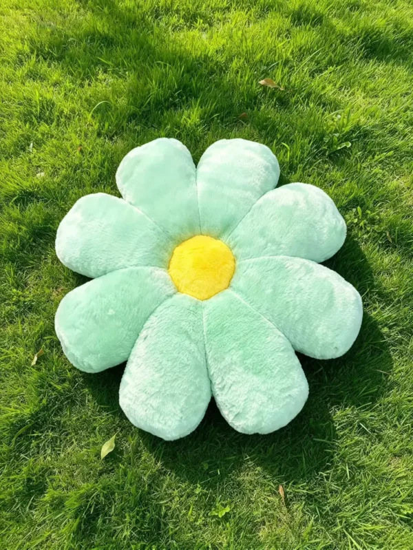 Mint zeleni Cuddle Puff jastuk u obliku cvetića sa žutom sredinom, na travi